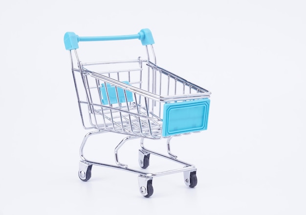 close-up of miniature shopping cart against white background