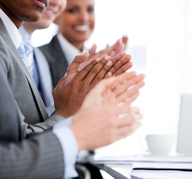 Photo close up of a  mixed business team applauding a presentation