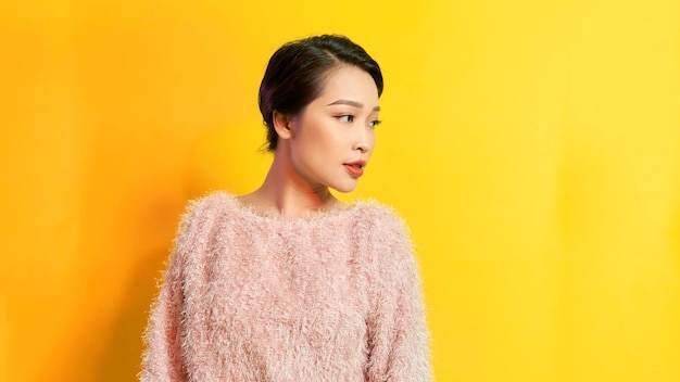 Close-up Mode vrouw portret van jonge vrij trendy meisje poseren tegen de achtergrond van een gele muur