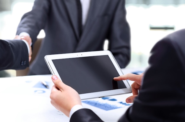 Close-up of a modern business team using tablet computer to work