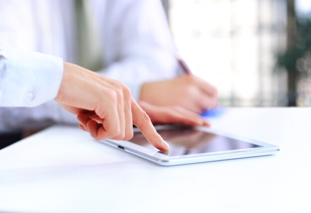 Close-up of a modern business team using tablet computer to work