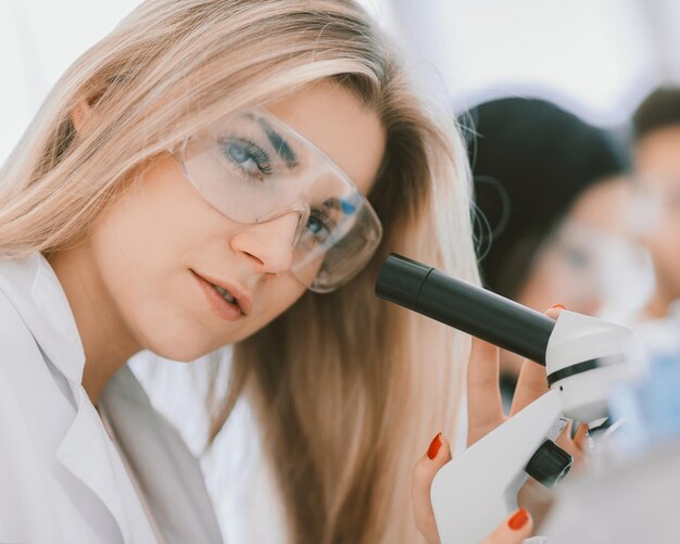 Photo close up.a modern female scientist looks into a microscope in a laboratory. science and health