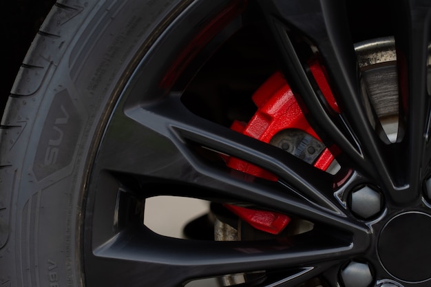 Close up of a modern wheel with red disk brake. Car brakes close up view. Clean car disc-brake.