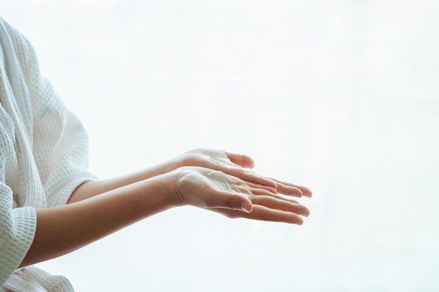 Close-up of moisturizer on palm of hands against white background