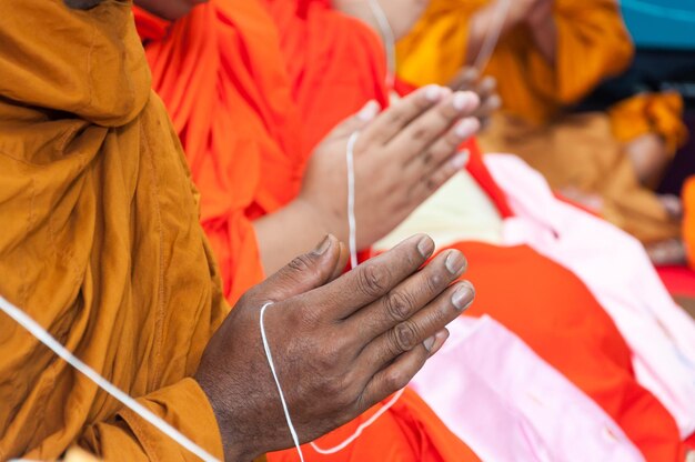 Close-up of monks praying with hands clasped