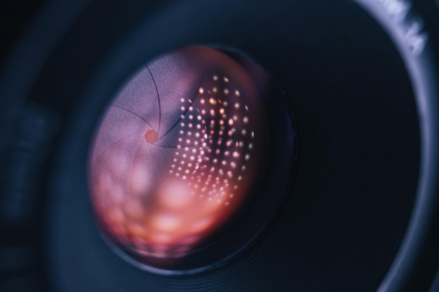 Foto close-up mooie camera lens op een donkere met rode reflectie licht achtergrond macro view