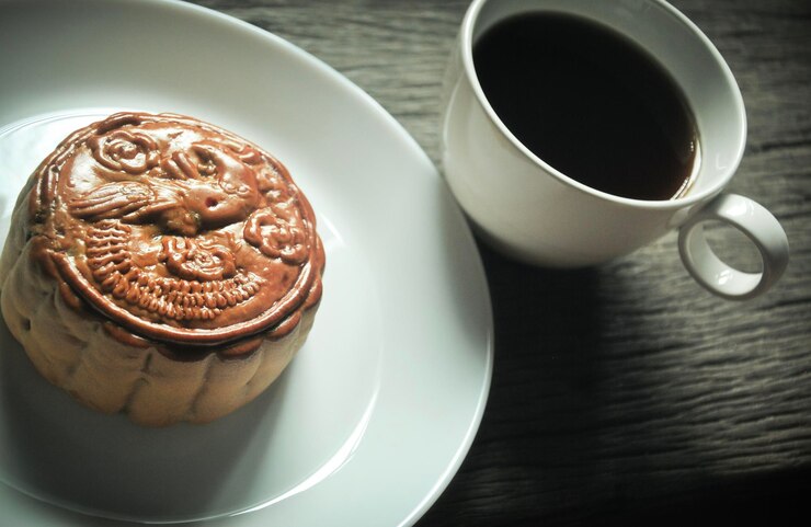 Photo 木製のテーブルの上の月のケーキとコーヒーカップのクローズアップ