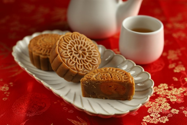 Закройте лунные торты с красным фоном. Mooncake — традиционная китайская выпечка.