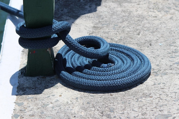 Close-up of mooring rope tied to cleat