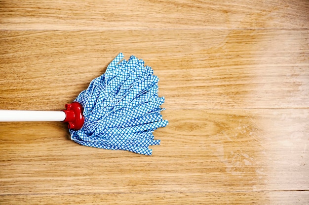 Photo close up of a mop cleaning dirty parquet at home