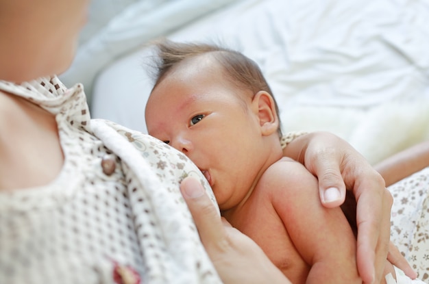 Close up mother breast feeding her newborn child.