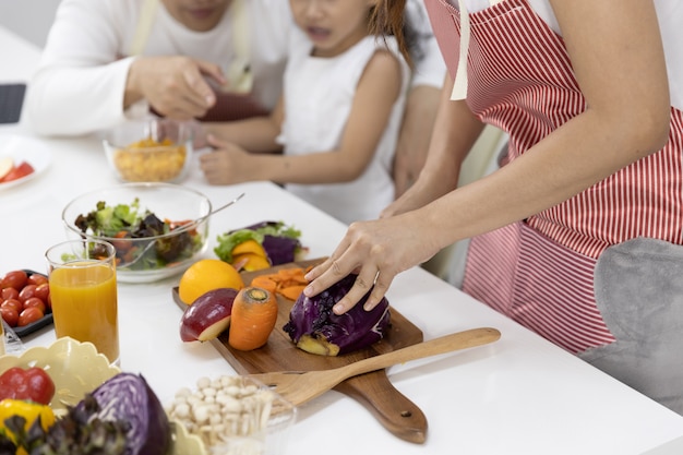 Close up of mother cutting vegetables in the kitchen