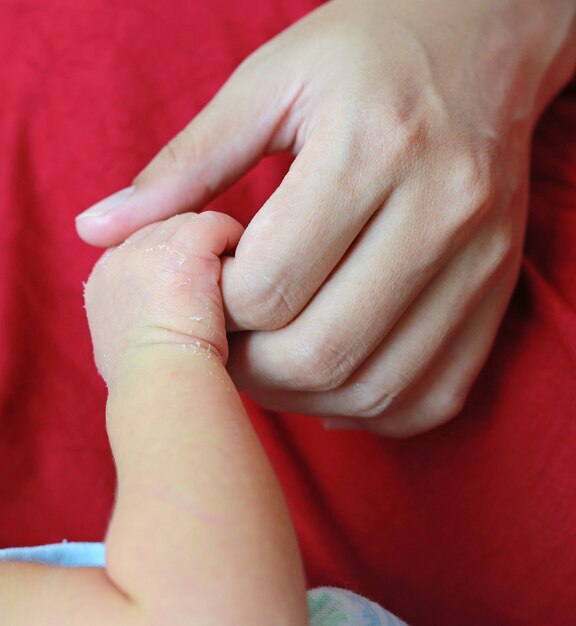 Close up mother's holding baby hand. Concept of love and family.