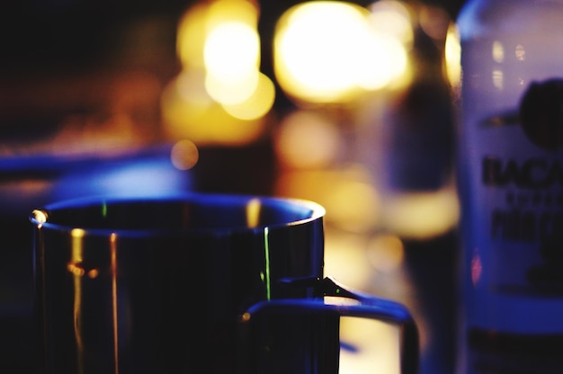 Foto close-up di una tazza contro luci sfocate a casa