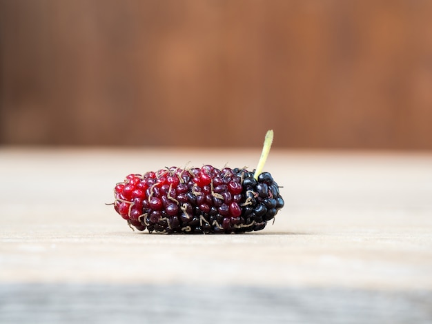 Photo close up of mulberry on wooden background