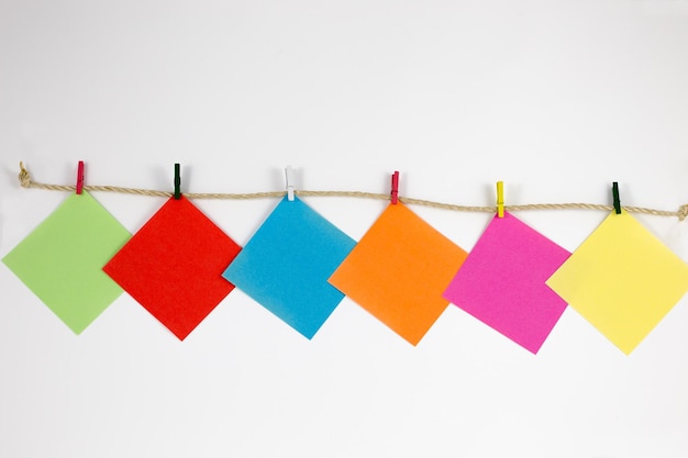 Photo close-up of multi colored adhesive notes against white background