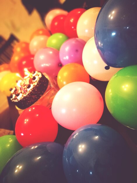 Close-up of multi colored balloons by cake