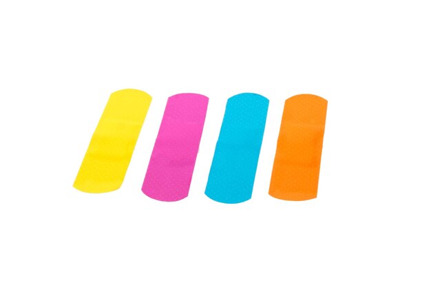 Photo close-up of multi colored bandages against white background