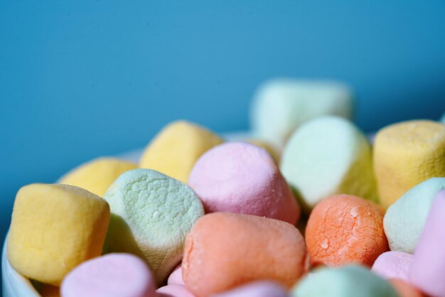 Close-up of multi colored candies against blue background