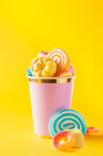 Close-up of multi colored candies against yellow background