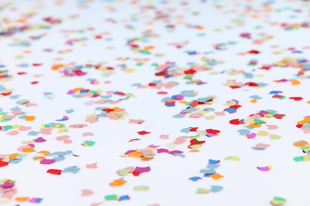Photo close-up of multi colored confetti on white background