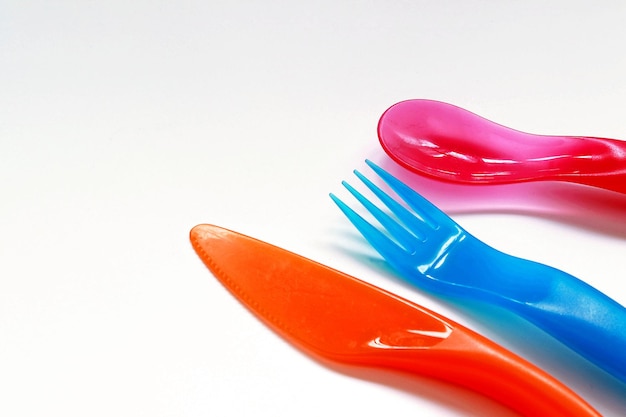 Photo close-up of multi colored eating utensils over white background