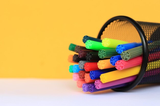 Close-up of multi colored felt tip pens in desk organizer on table