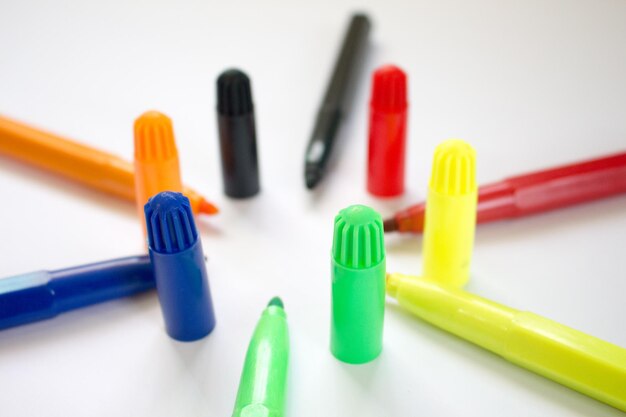 close-up of multi colored felt tip pens over white background