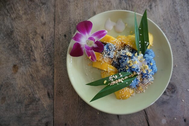 Photo close-up of multi colored flower in plate on table