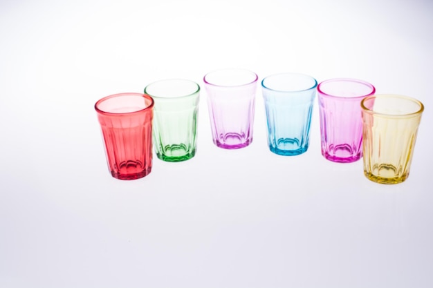 Photo close-up of multi colored glasses against white background