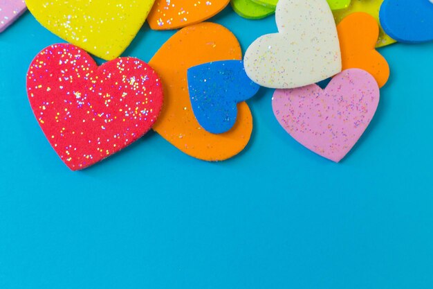 Close-up of multi colored heart shape over blue background