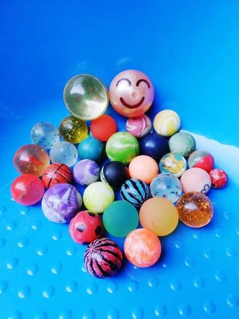 Close-up of multi colored marbles on blue table