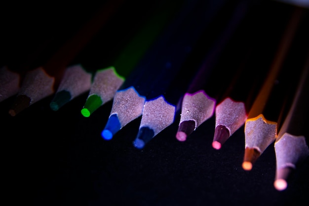 Photo close-up of multi colored pencils over black background