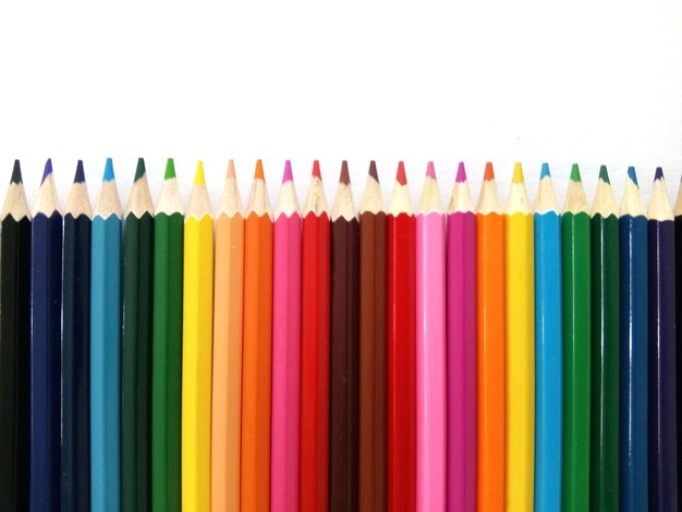 Photo close-up of multi colored pencils over white background