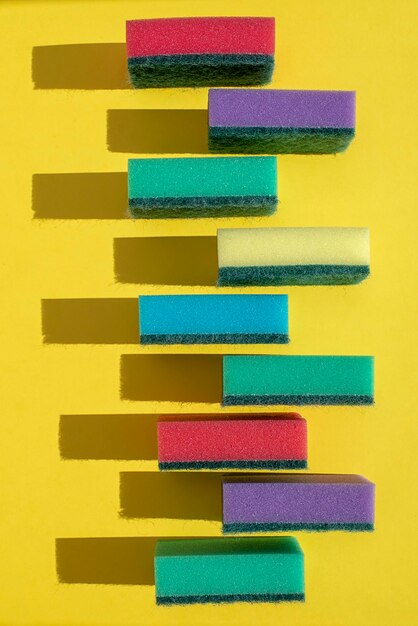 Photo close-up of multi colored sponges against yellow background