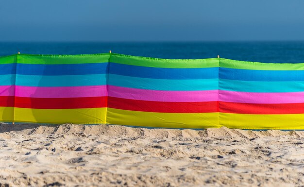 Photo close-up of multi colored umbrella on beach against sky