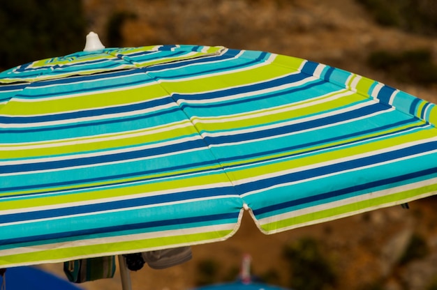 Close-up of multi colored umbrella on beach