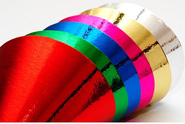 Close-up of multi colored umbrellas on table against white background