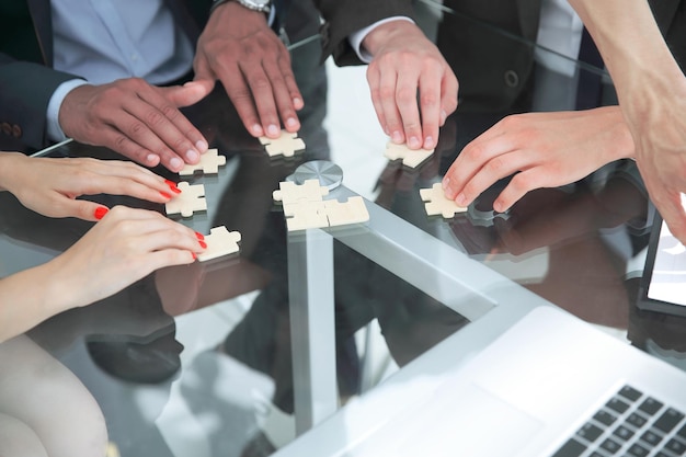 Close up multinational business team assembling puzzle