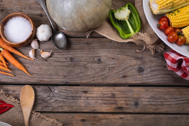 Photo close up of multiple food ingredients and cutlery with copy space on wooden surface