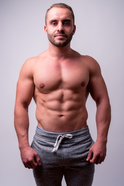 Close up of muscular bearded man shirtless isolated