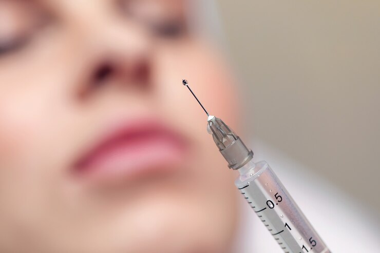 Close-up Naald van een injectie in een schoonheidssalon. Er zit een kleine druppel vloeistof aan de punt van de naald.