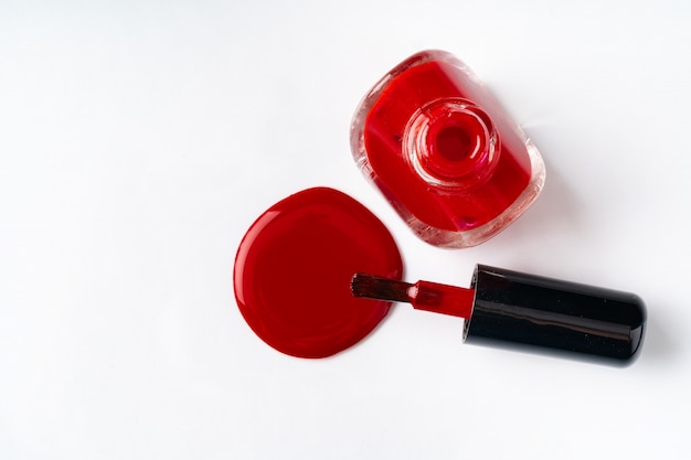 Close up of a nail polish puddle over white table