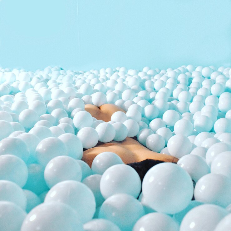 Photo close-up of naked person lying down in ball of pool