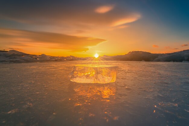 Primo piano del ghiaccio di rottura naturale su acqua congelata al tramonto nel lago baikal, siberia, russia.