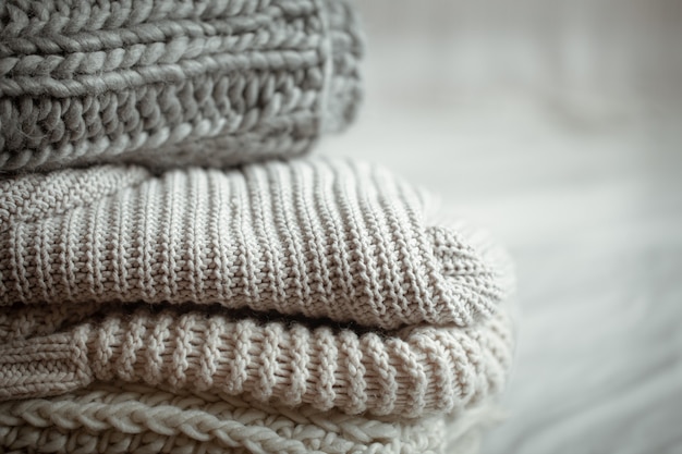 Close up of neatly folded knitted items of pastel color.