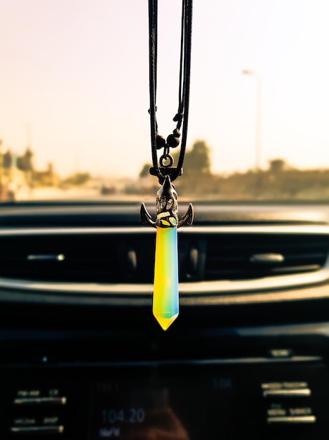 Photo close-up of necklace hanging in car