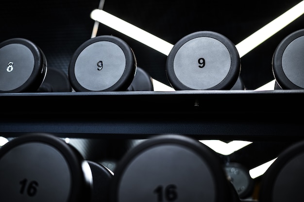 Close up of new dumbbells on a rack in a gym