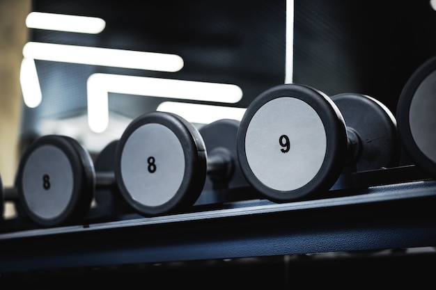 Close up of new dumbbells on a rack in a gym