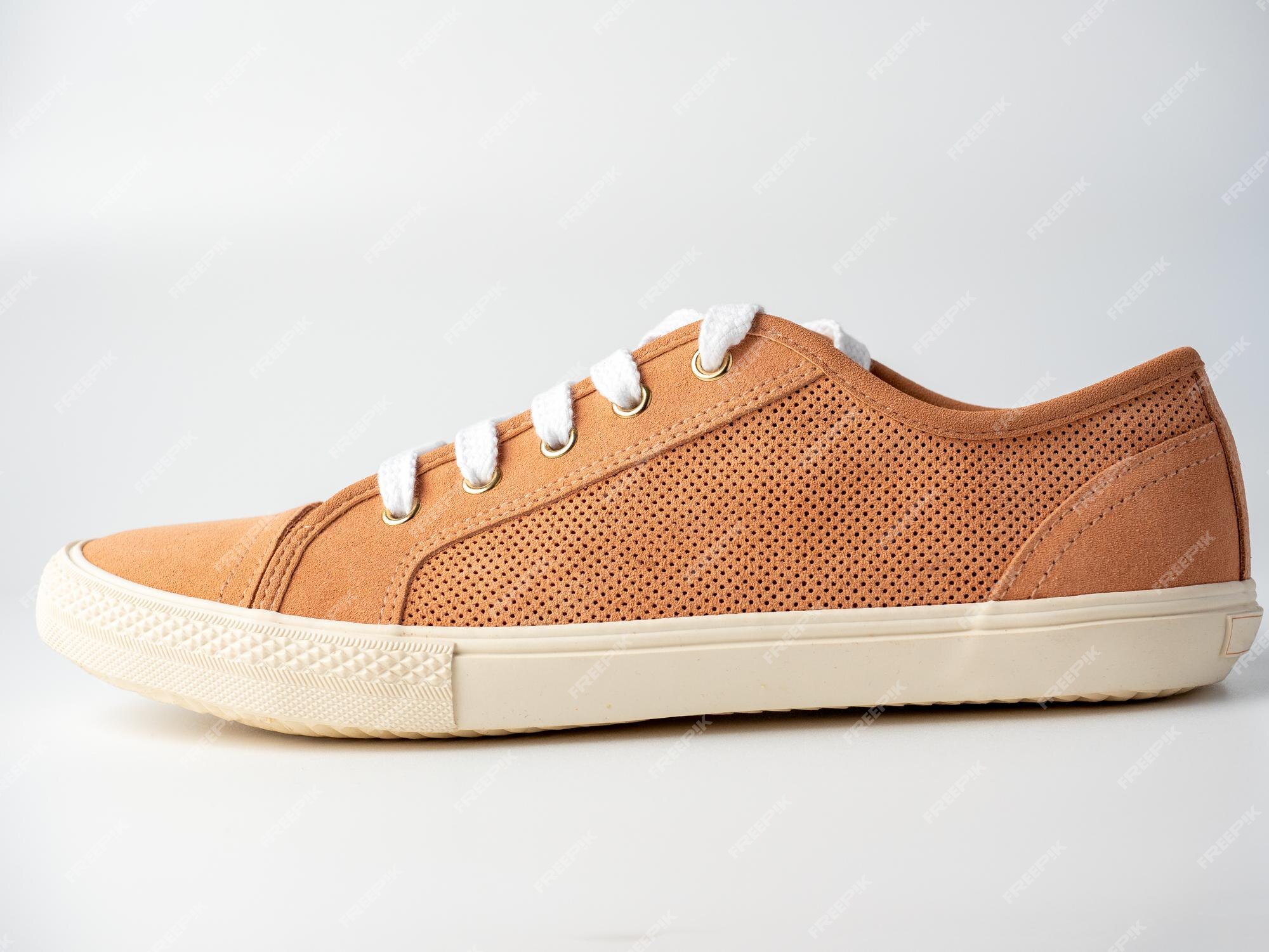 Premium Photo | Close-up of new light brown sneakers with white laces on a  white background. nubuck suede leather. front view